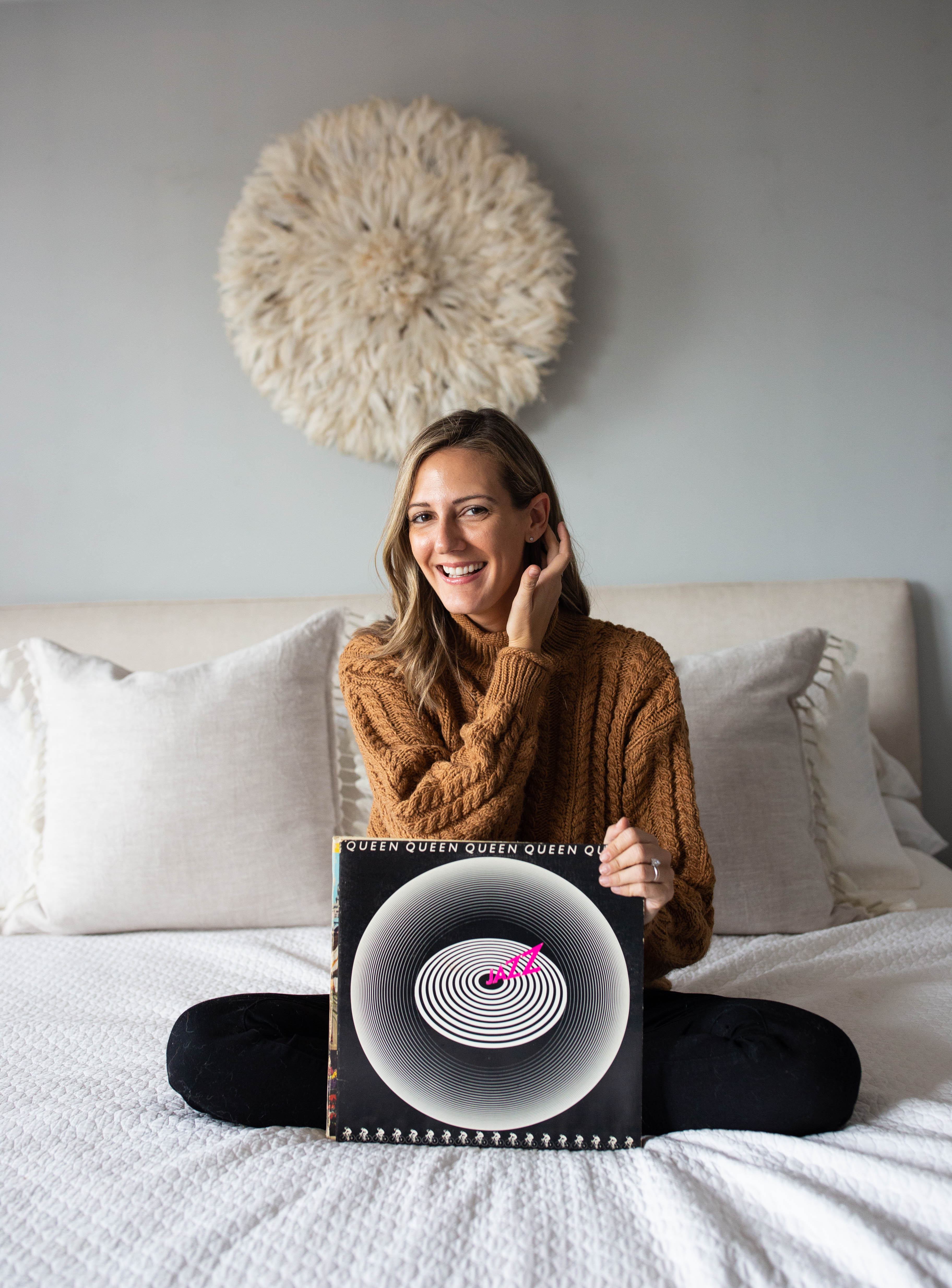 woman smiling and showing her old vinyl records