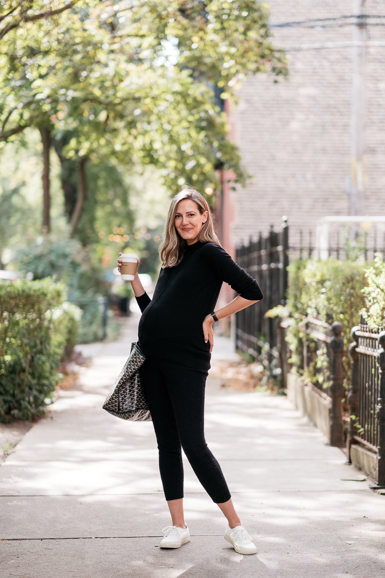 woman wearing all black outfit from Banana Republic and holding a drink