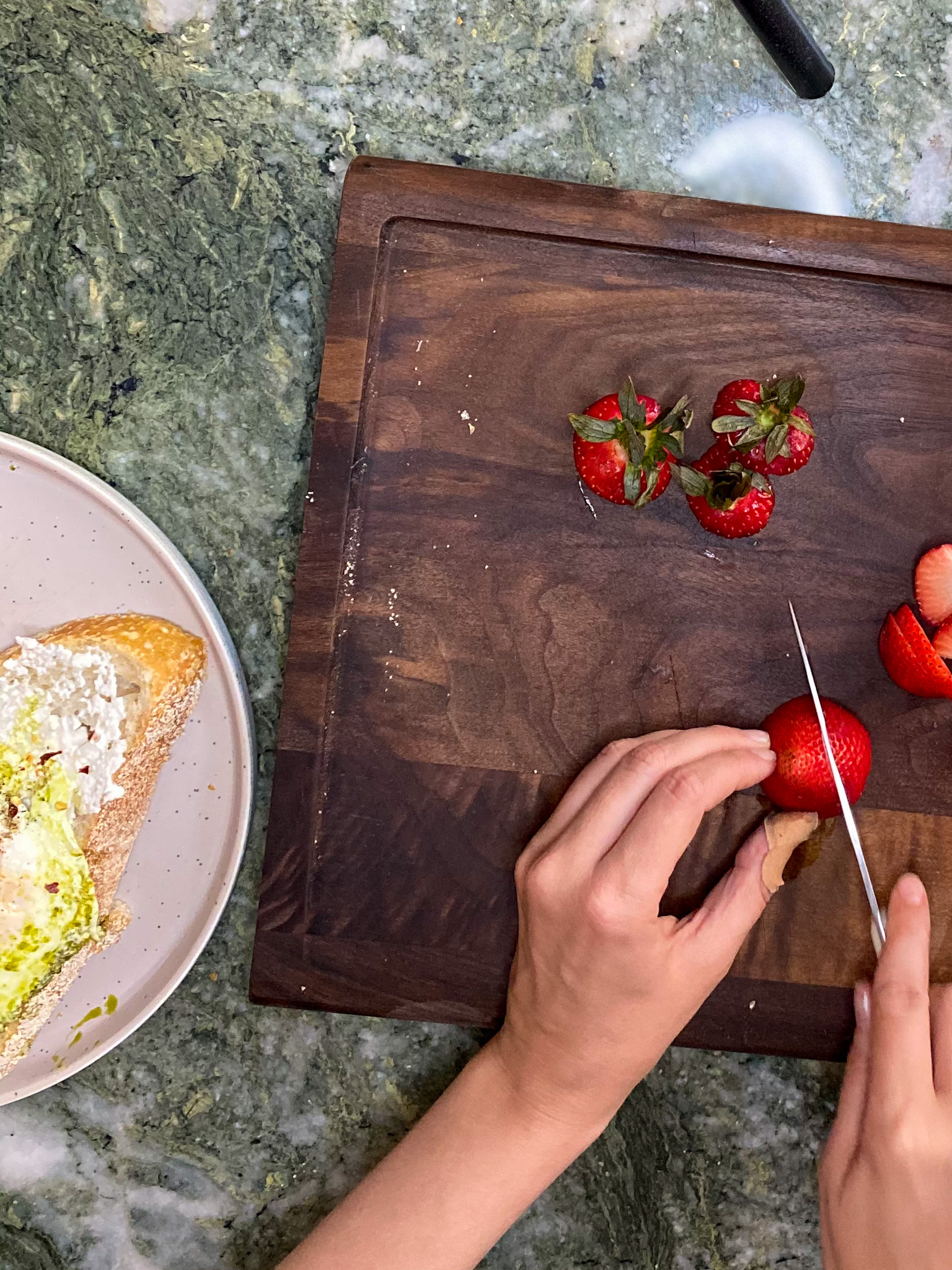 woman slicing strawberries on a chop board