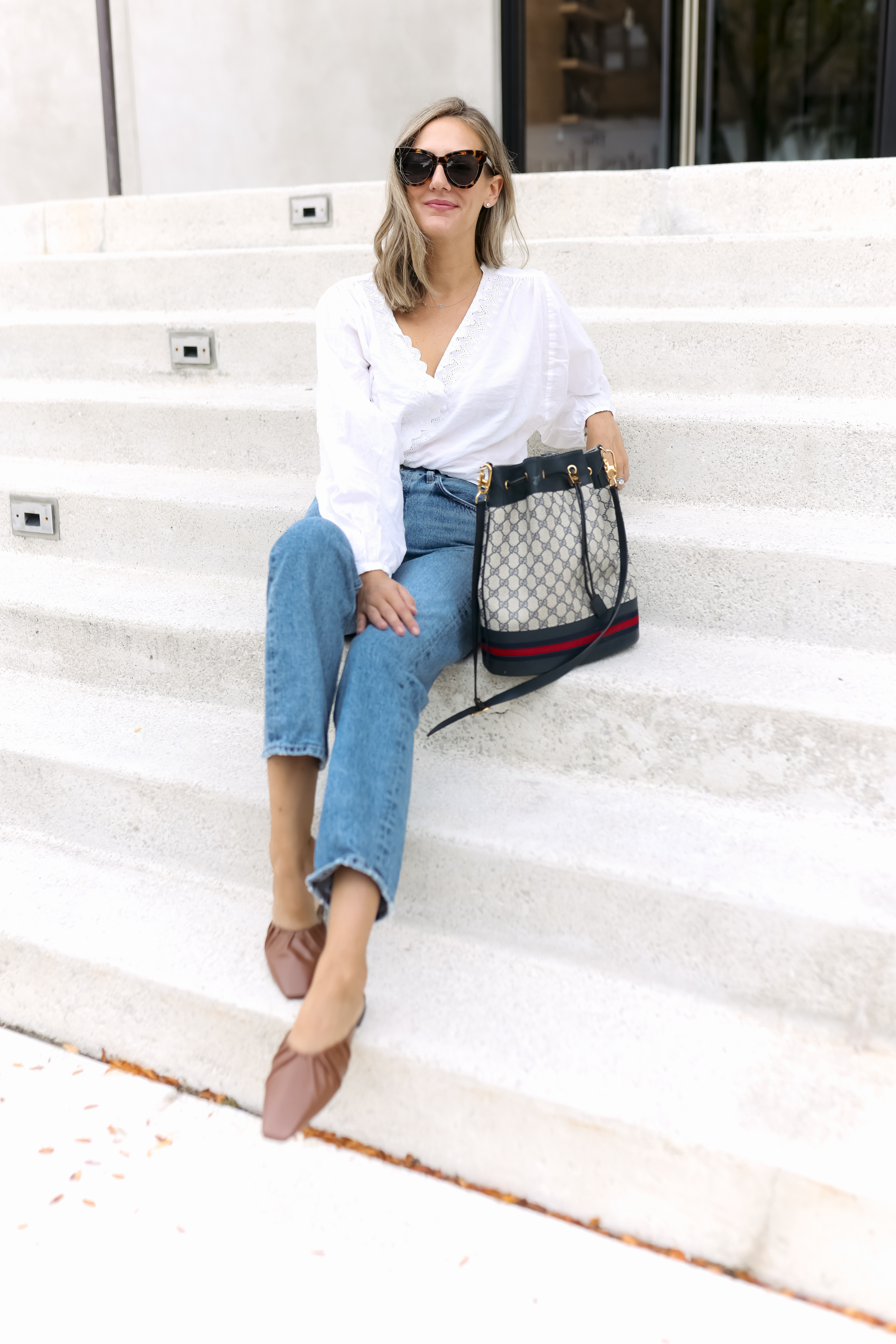 woman wearing white top and jeans from her Fall Capsule Wardrobe