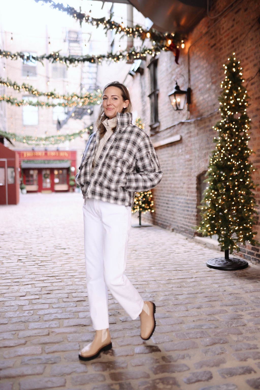woman in sweater and white pants sharing Holiday Gifting with Urban Outfitters