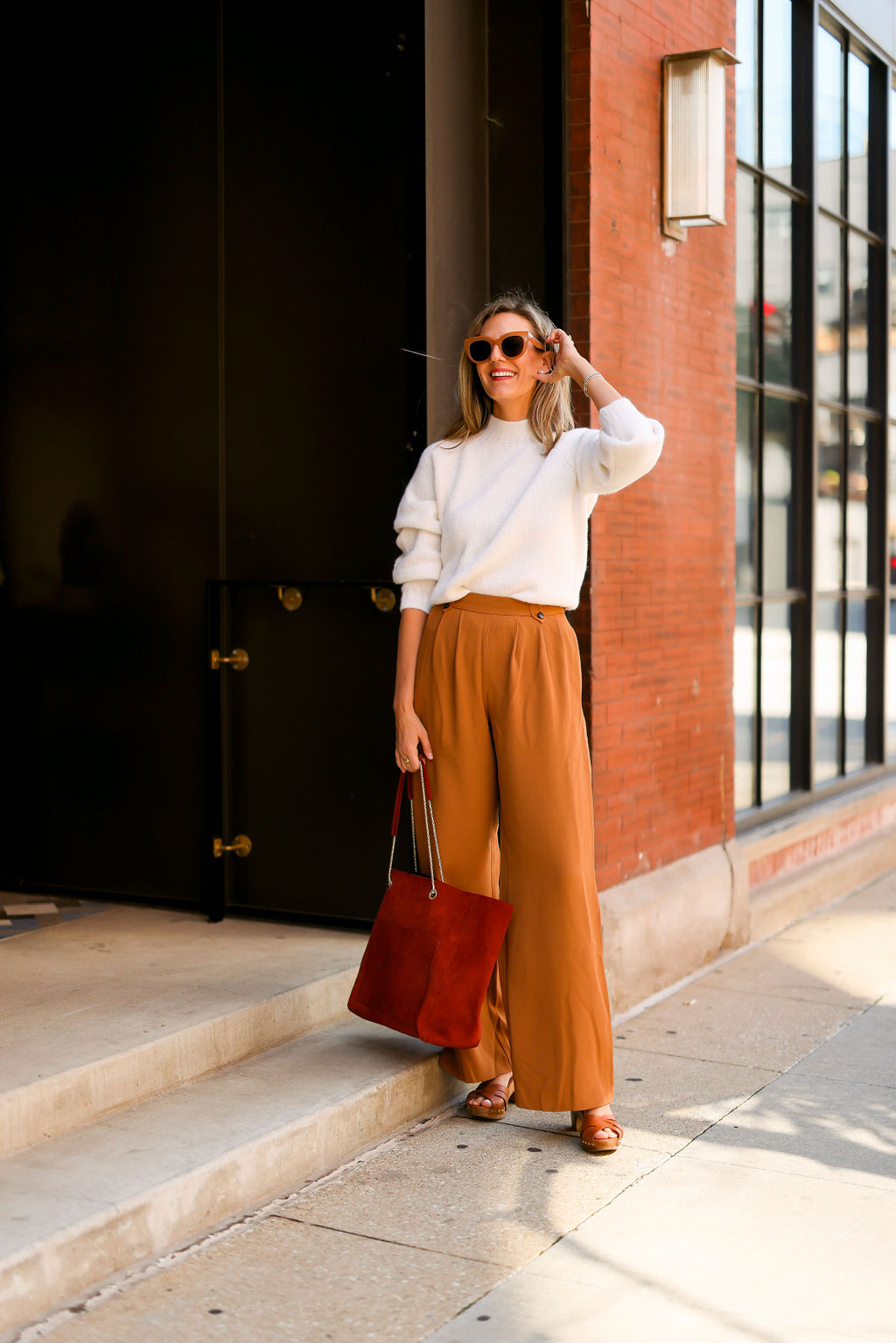 woman wearing Sézane sweater and pants and a red bag for an Easy Fall Looks