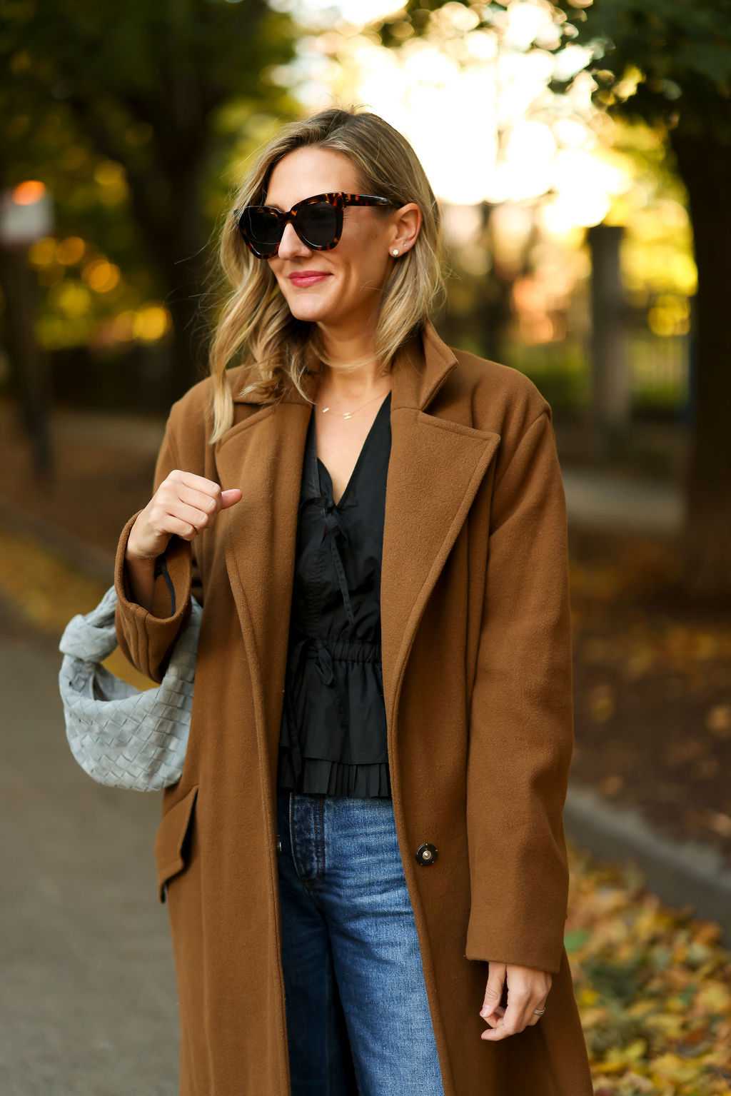woman using Bottega Veneta Mini Jodie and wearing coat