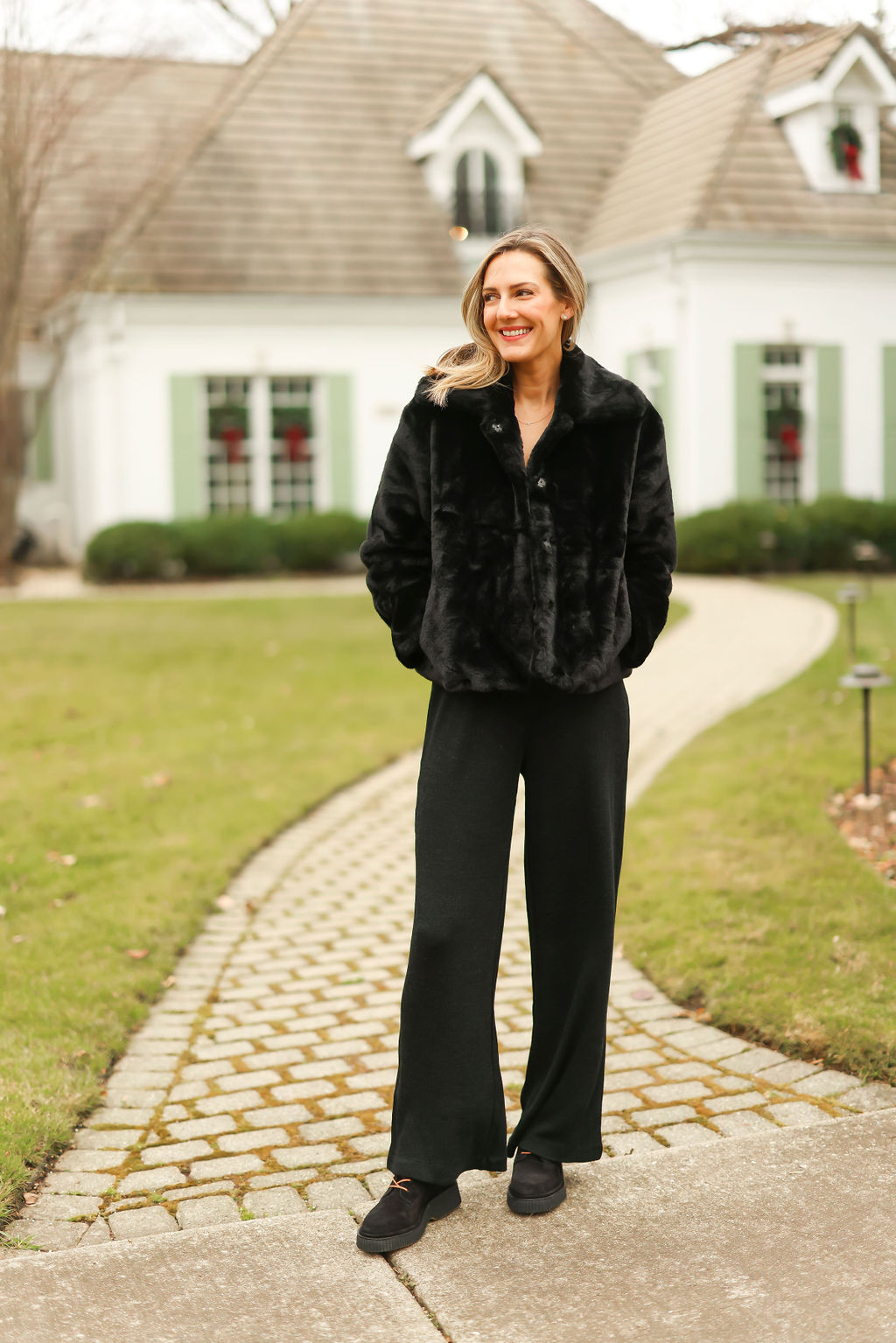 woman smiling and Getting Cozy in her all black outfit