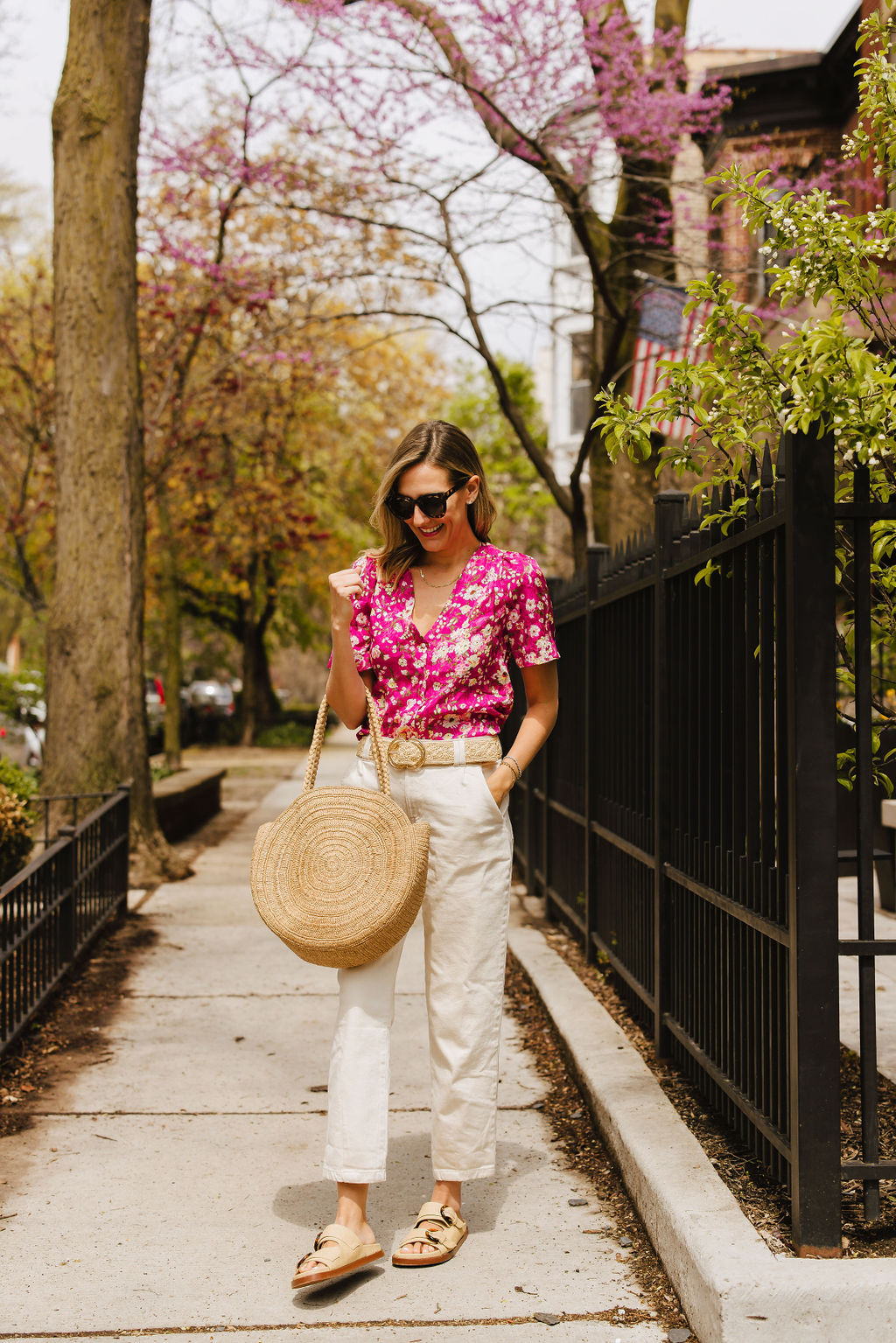 for Classic Style with Sézane woman wears floral top, white pants, and weaved bag